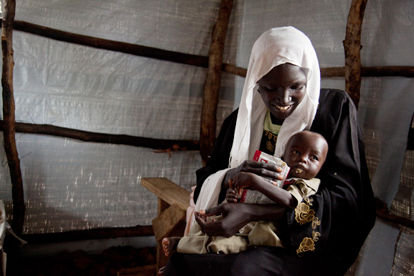 A woman feeding her child at Yusuf Batil refugee camp